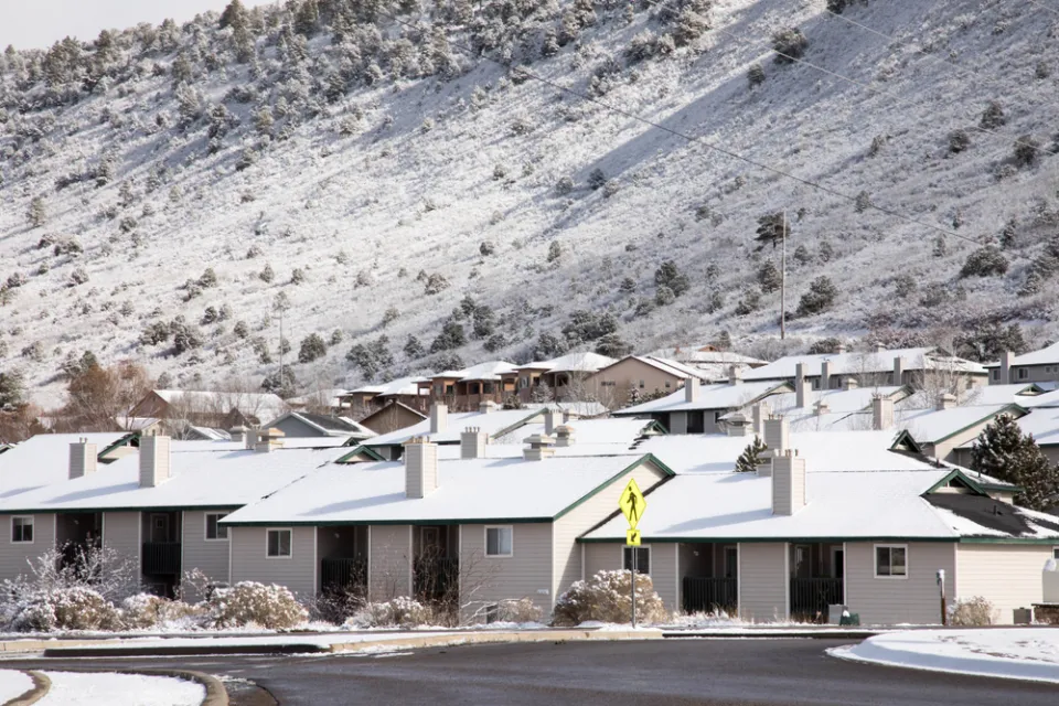 One-story houses dusted with snow in Durango, Colorado with snowy mountainside in background